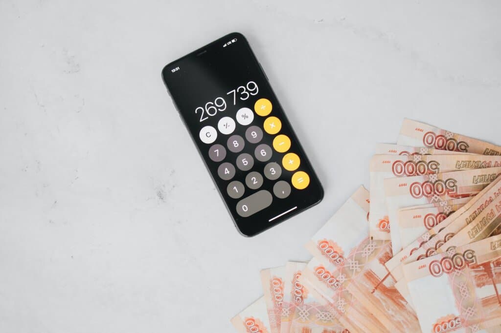 a cellphone calculator and cash on a flat surface